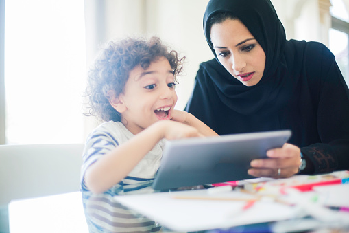 Middle eastern mother helping her child with homework